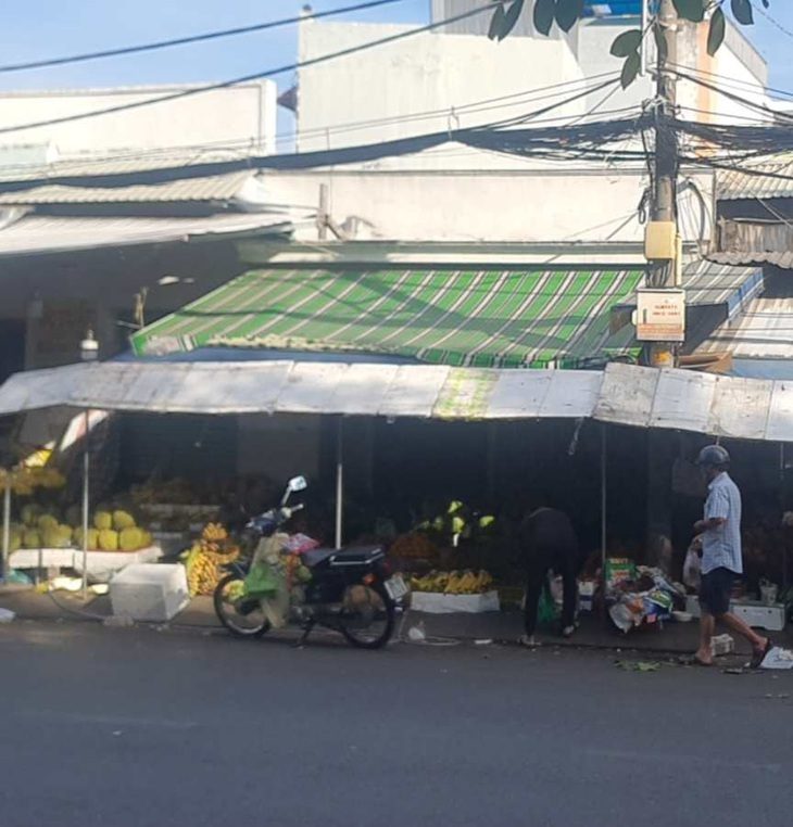 Căn nhà ở quận 7 bị ép đấu giá rẻ mạt, thanh tra vào cuộc thấy ngay dấu hiệu thông đồng- Ảnh 1. Căn nhà bà L.T.K.C (hiện được sử dụng phía trước làm sạp bán trái cây) là tài sản thi hành án được kết luận thanh tra chỉ ra có dấu hiệu thông đồng trong bán đấu giá - Ảnh: ÁI NHÂN