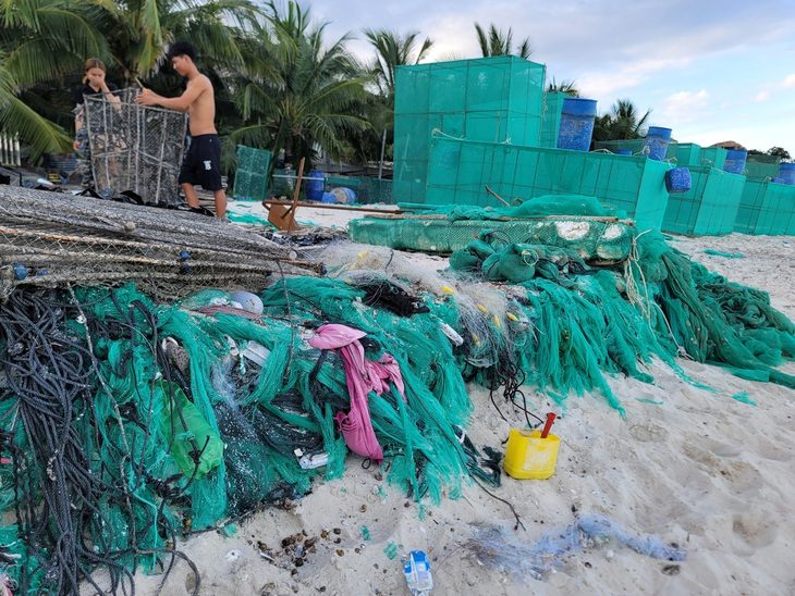 Biển Cam Ranh bị ô nhiễm vì rác thải từ lồng nuôi tôm hùm - Ảnh 1. Đủ loại rác thải như nhựa, lưới... chất thành đống tại bãi biển thuộc thôn Bình Lập - Ảnh: TRẦN HƯỚNG