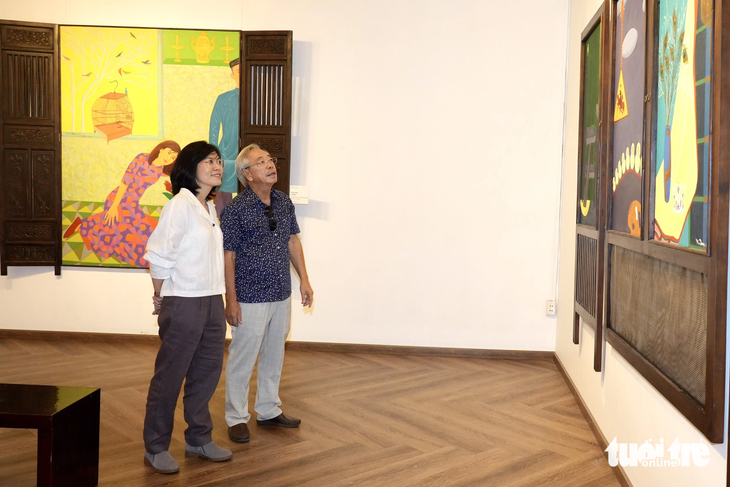 Hai cha con họa sĩ Nguyễn Ngọc Đan xem loạt tranh triển lãm - Ảnh: HỮU HẠNH Hai cha con họa sĩ Nguyễn Ngọc Đan xem loạt tranh triển lãm - Ảnh: HỮU HẠNH