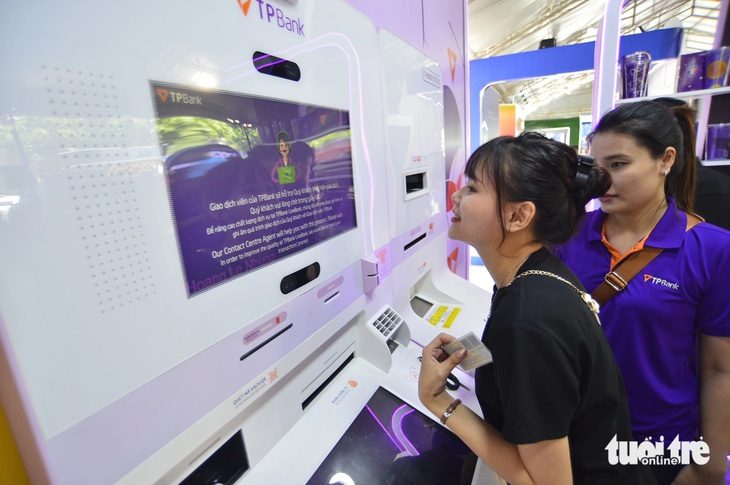 Bất ngờ khi được in hình lên thẻ ngân hàng TPBank- Ảnh 1. Các bạn trẻ thích thú với trải nghiệm in chân dung khi mở thẻ FreeGo - Ảnh: QUANG ĐỊNH